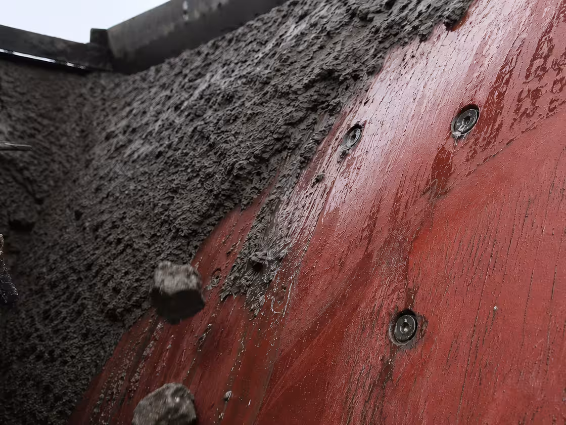 A soft rubber lining works under the stream of material and throws sticky buildup off, instead of holding it fast. (AI-generated image)