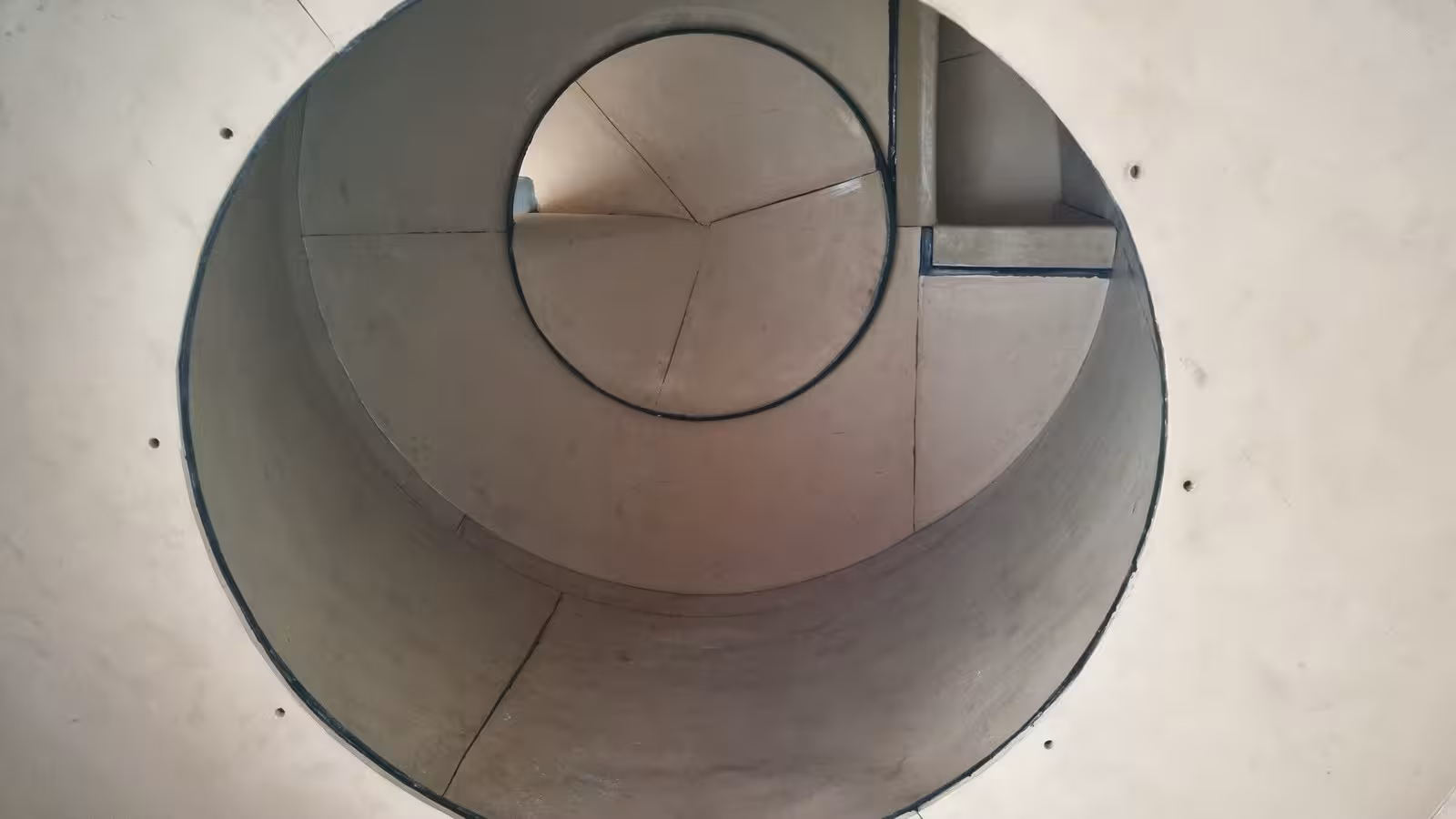 Rubber-lined instead of worn: precisely cut beige wear-resistant rubber lines this granulating drum. What gets abraded is the lining, not the steel beneath it.